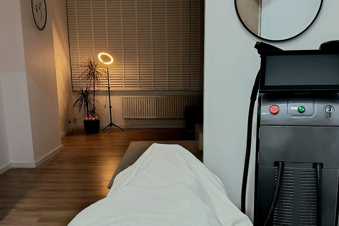 De behandelkamer in de avond, met warme ringlamp naast de behandeltafel.