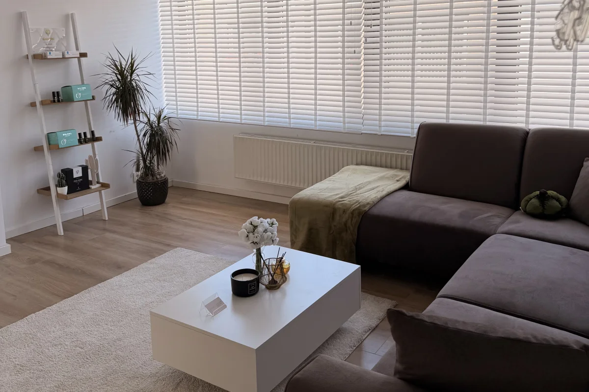 De wachtruimte met zithoek, planten en een rek met verzorgingsproducten.
